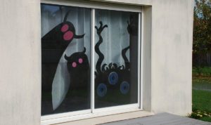 monstres d'halloween en papier collés sur les vitres